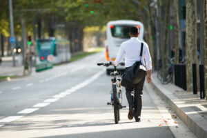 businessman walking with bike on street